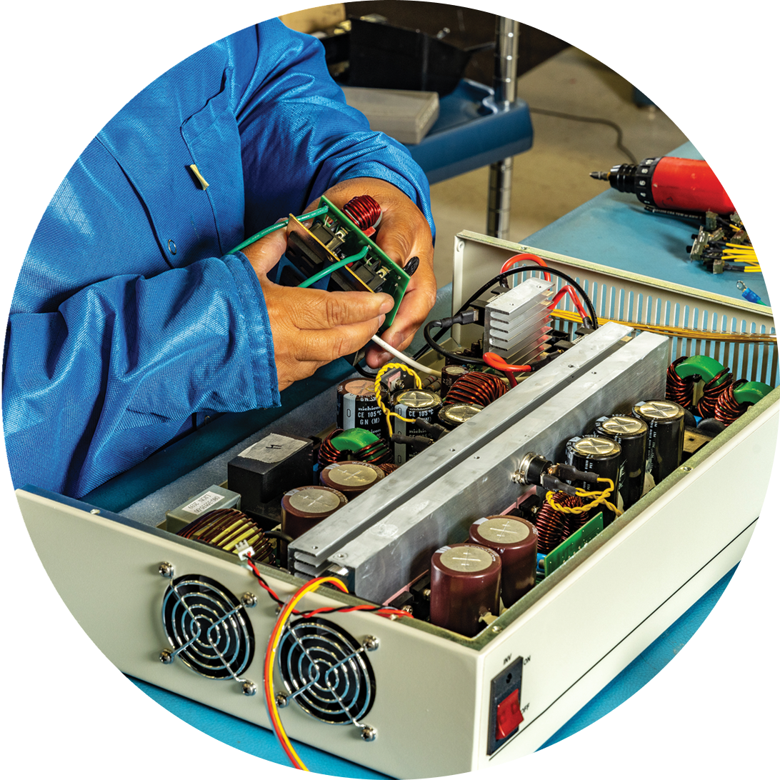 Person assembling electronic equipment in workshop.