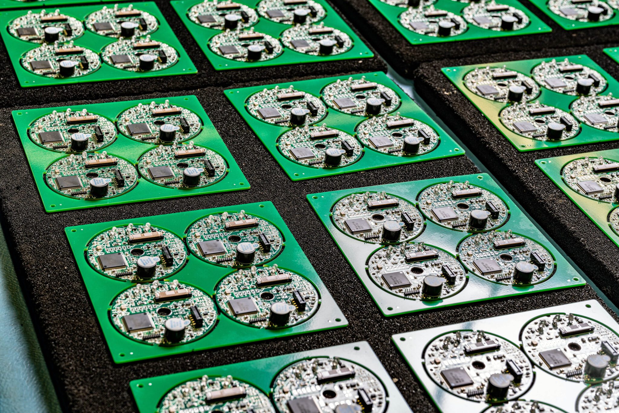 Green printed circuit boards in rows.