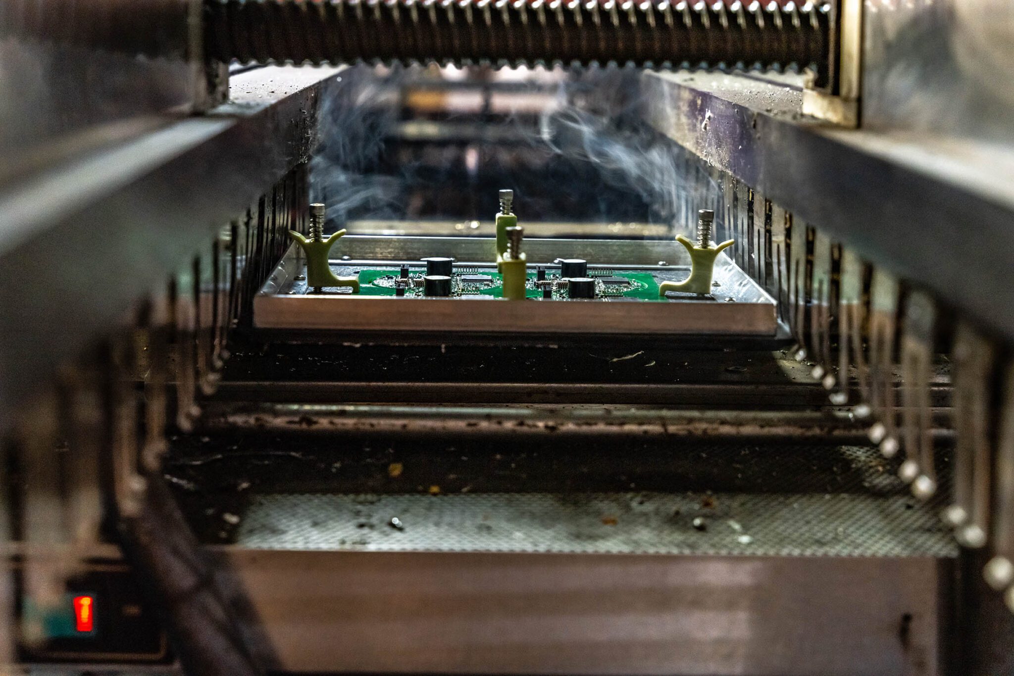 Circuit board in manufacturing process, under machinery.