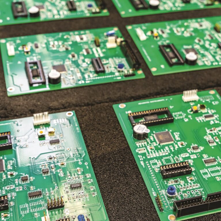 Green electronic circuit boards on display table.