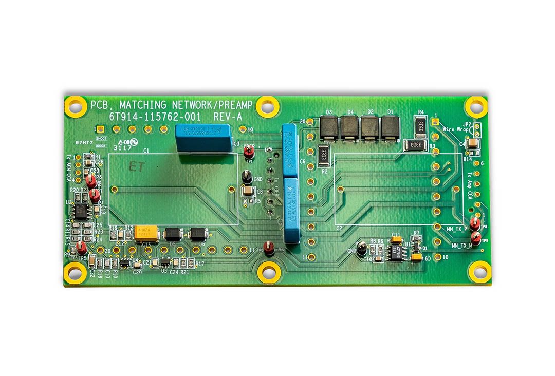 Green circuit board with various electronic components.