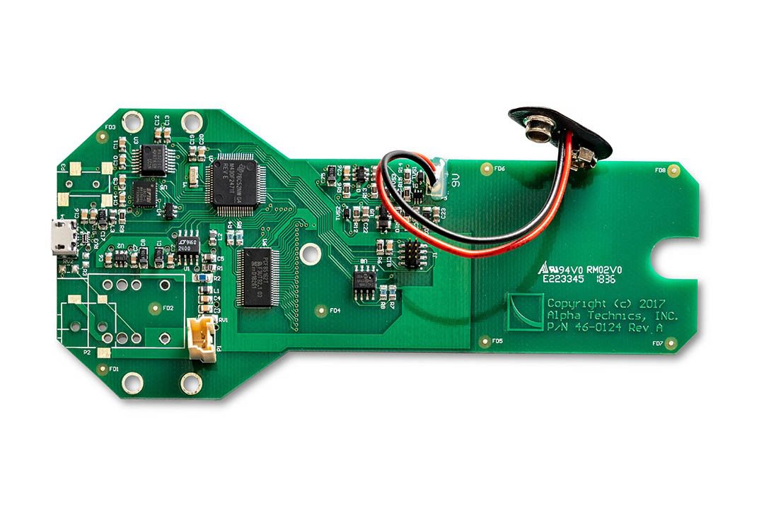 Green electronic circuit board with attached wires.