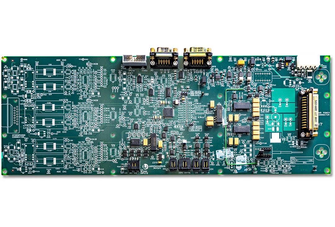 Green electronic circuit board with various components.