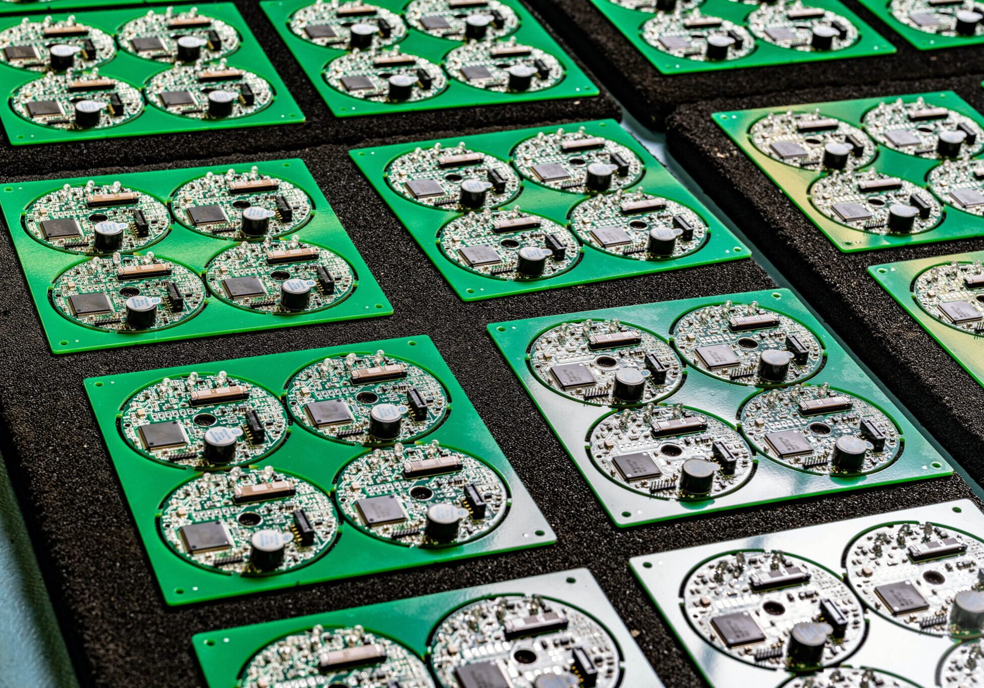 Green printed circuit boards in rows.